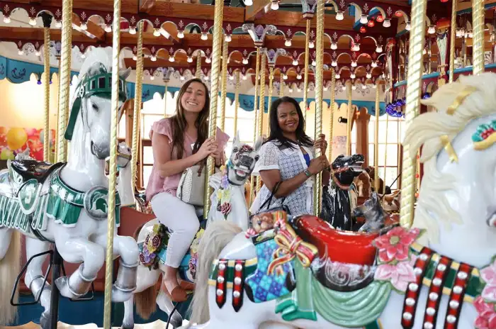 Two people riding the carousel.
